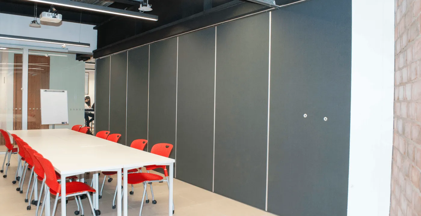 Muro móvil sonó-aislante con acabado gris en una sala de juntas